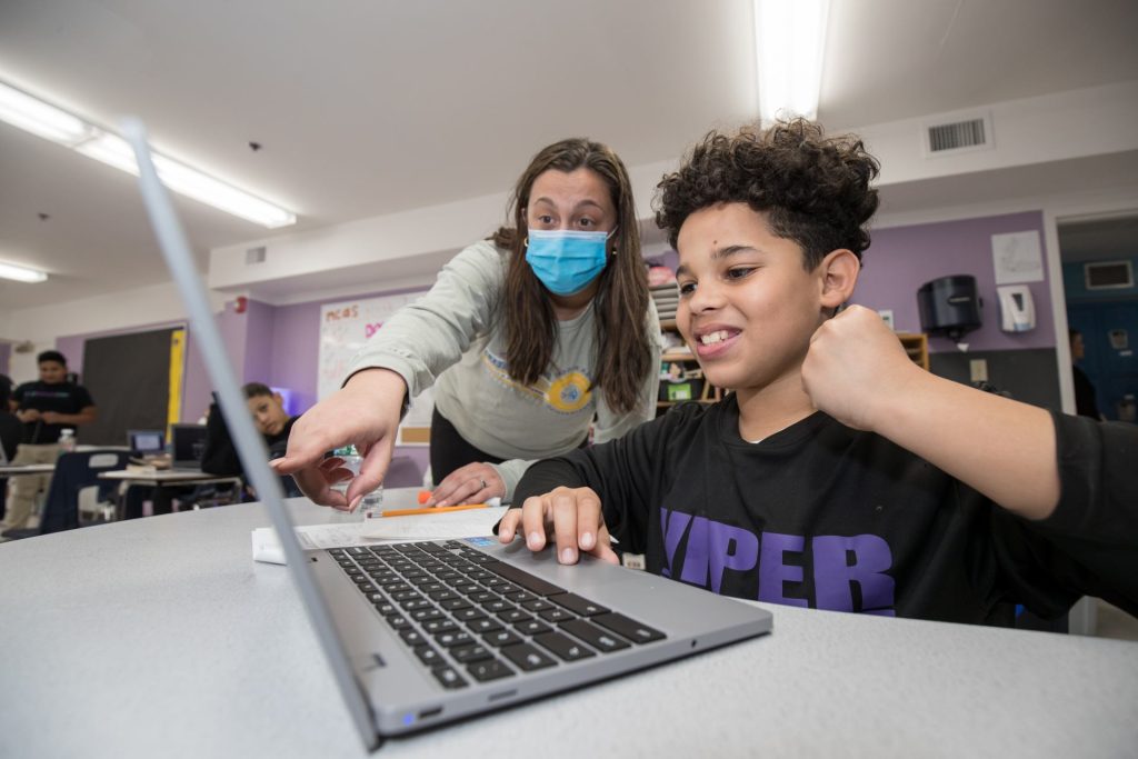 Teacher helping student with computer