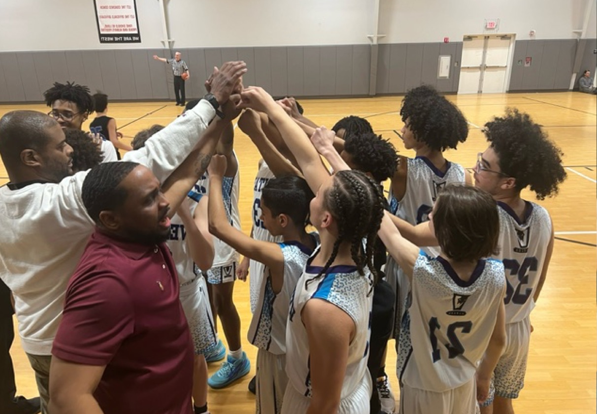 Photo of school basketball coaches with team cheer