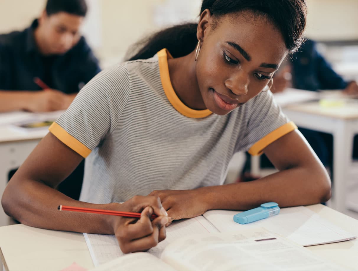 High school student writing at her desk 