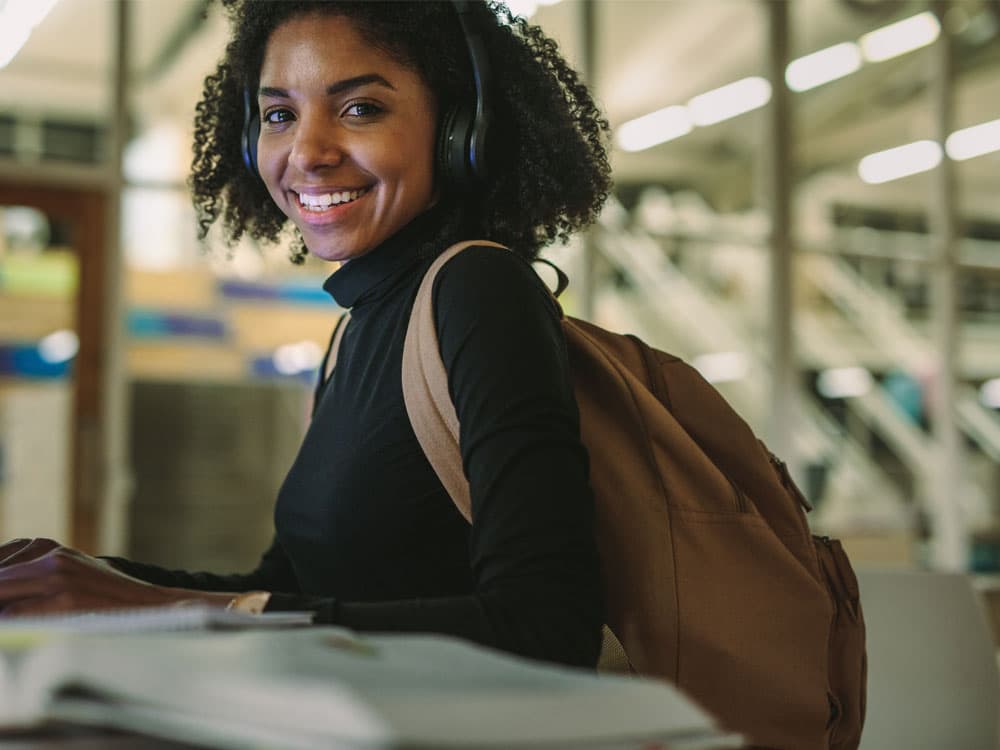 Student wearing a backpack smiling 