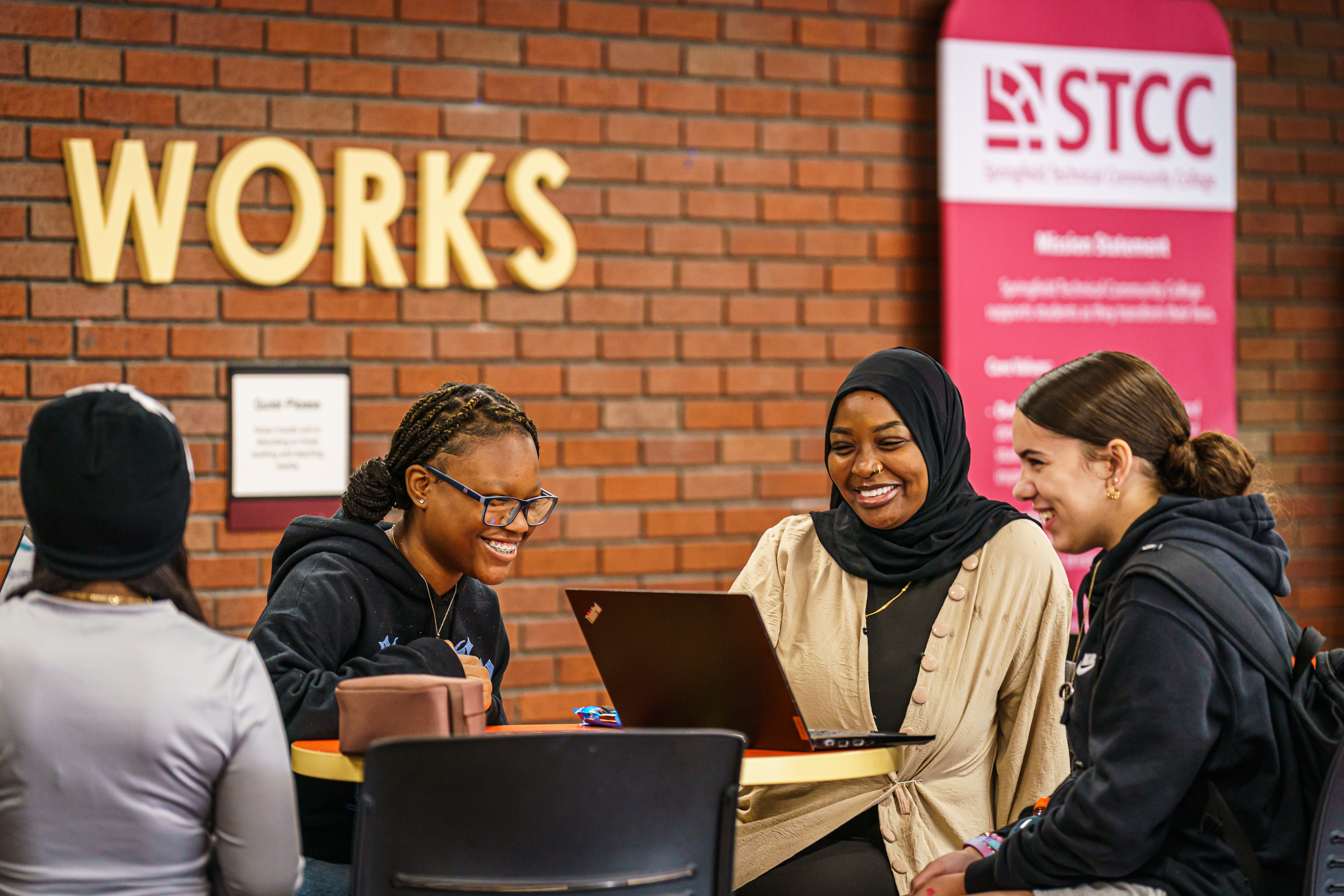 Young female student raising her hand and smiling